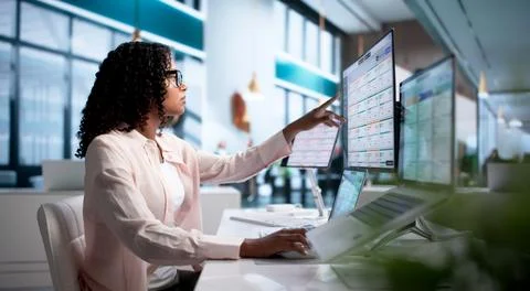 Young Business Analyst Using Integrated ERP Software On Laptop And Desktop. Stock Photos