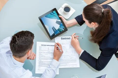 Young business couple discussing rental agreement. Foto stock