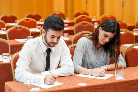 Young business couple taking notes in conference room. Stock Photos