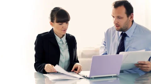 Young business couple working with documents in front of the laptop Stock Footage 1970029