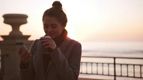 Young business girl drinking coffee and surfing internet using mobile phone Stock Footage
