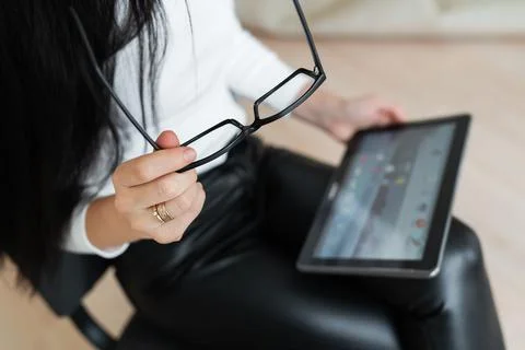 A young business girl solves problems online on a tablet. Young woman chattin 写真素材