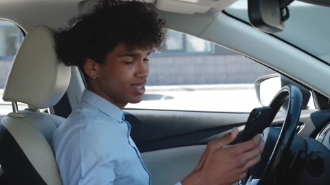 Young, business guy of ethnicity scrolls the news feed on the smartphone while Video stock 180399260