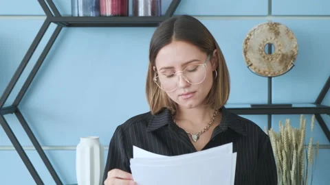 A young business lady looks at the documents. She stands in the office Stock Footage 130870053