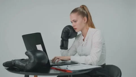 Young business lady working at the computer in boxing gloves after work she goes Stock Footage 157936247
