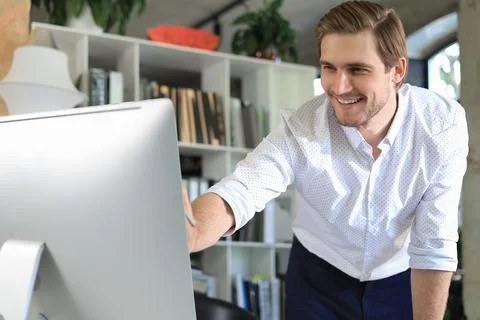 Young business man analyzing data using computer while working in the office. Foto stock