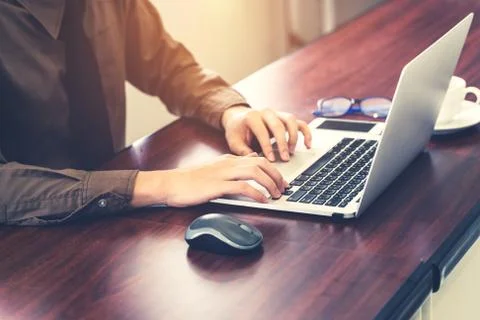 Young business man hand using computer laptop in the office with sunlight. .. Stock Photos