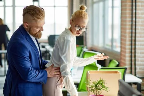 Young business man harassing office woman sexually in modern office Stock Photos