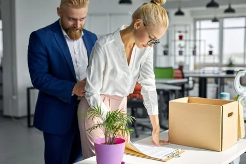 Young business man harassing office woman sexually in modern office Stock Photos
