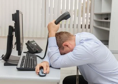 Young business man with problems and stress in the office sitting in front of Stock Photos