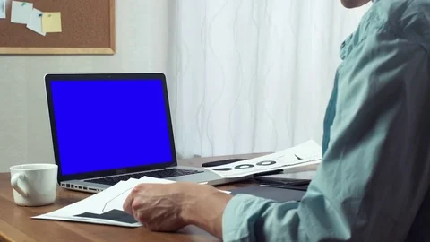 Young business man using digital tablet working with printed analyzing graphs Stock Footage 81879924