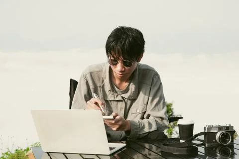 Young business man working computer on peak hill. Hiker online shopping on .. Foto stock
