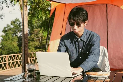 Young business man working computer on peak hill. Hiker online shopping on .. Stock Photos