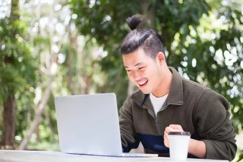 Young business man working on laptop computer while sitting in vintage cafe b Stock Photos