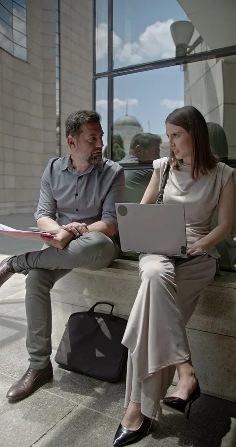Young Business Partners Collaborating and Discussing Work Together Outdoors in Stock Footage 315815933