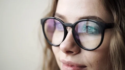 Young business woman in glasses looking far away, over a white background Stock Footage
