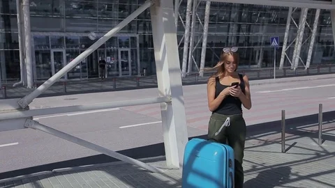 Young business woman with luggage at the airport waiting for a bus Stock Footage