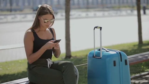 Young business woman with luggage at the airport waiting for a flight. Stock Footage