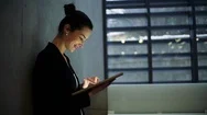 Young Business Woman With Tablet Walking In Office, Concrete Wall In Background. Stock Footage