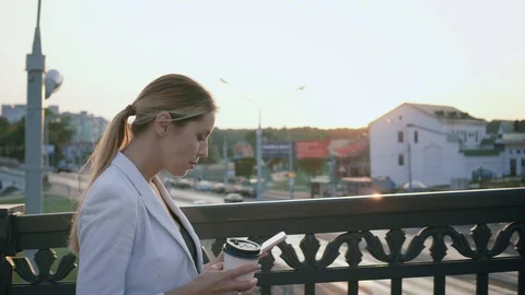 Young business woman in a white jacket walking in the morning in the city, write Stock Footage 101600053