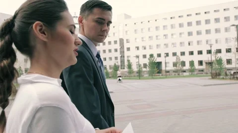 Young businessman and businesswoman walking to the office together Stock Footage