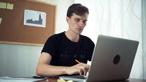Young businessman attaching sticky note and analyze graphs to board in office Stock Footage 79899655