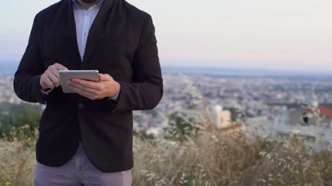 Young businessman in black blazer using tablet outdoors, close up Video stock 133374568
