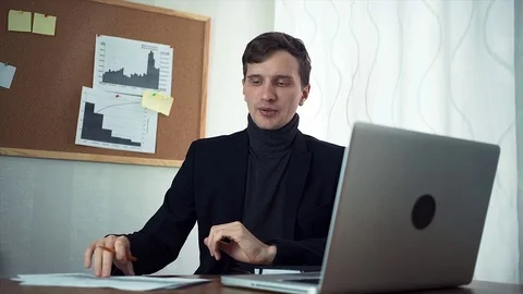 Young businessman chatting with customer using laptop computer Video stock 79900125