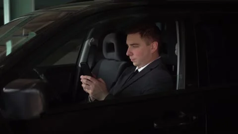 Young businessman chatting on the phone while sitting in the car in the parking Stock Footage 218508792