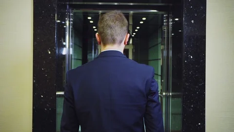 Young businessman comes into elevator slow motion backside Stock Footage 105246975