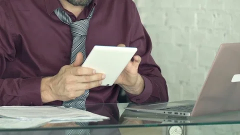 Young businessman comparing data on tablet and laptop by table in kitchen Stock Footage 82488729