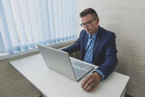 Young businessman concentrating on computer work, looking at laptop screen,.. Stock Photos