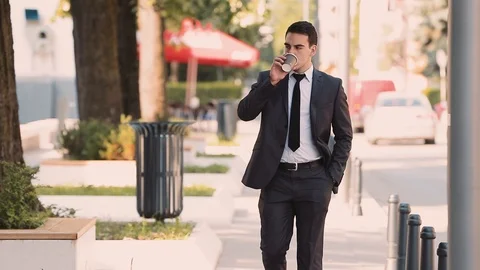 Young Businessman Drinking Coffee While Walking Stock Footage 87406084