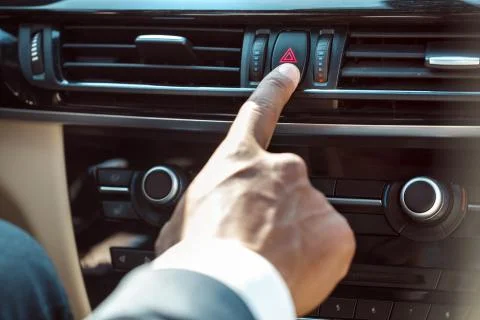 Young businessman driver sitting inside car pushing emergency button close-up Stock Photos