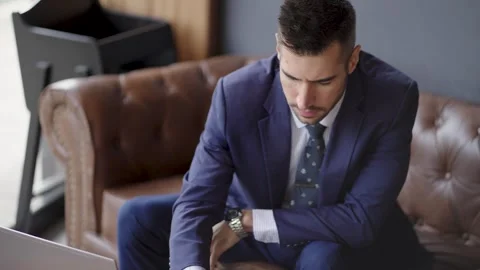 Young businessman enjoying a coffee while he works on his laptop in a coffee Stock Footage 340204544