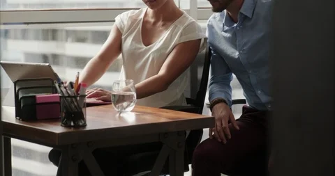 A Young Businessman Explaining Something to His Attractive Female Coworker Stock Footage 100426918