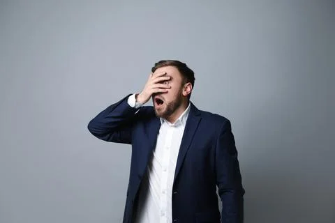Young businessman feeling fear on grey background Stock Photos