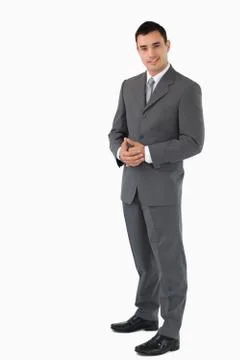 Young businessman with hands folded against a white background Stock Photos