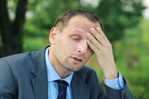 Young businessman having headache while working in documents  in the garden NTSC Vídeo Stock 40335992