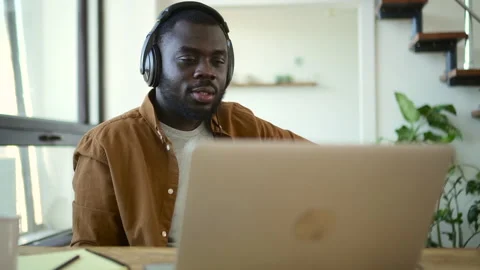 Young businessman having online conversation and sitting at table with laptop in Stock Footage 158366248