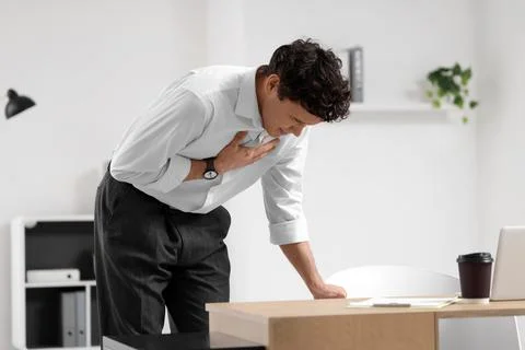 Young businessman having panic attack at desk in office Stock Photos