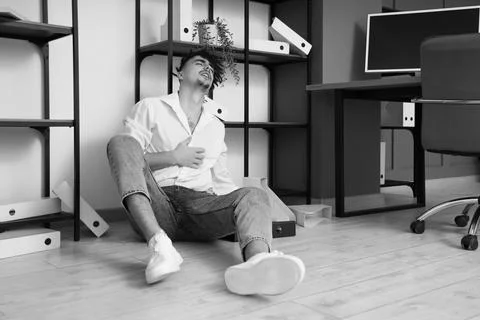 Young businessman having panic attack on floor in office Stock Photos