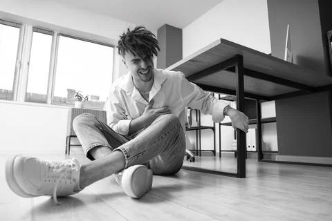 Young businessman having panic attack on floor in office Stock Photos