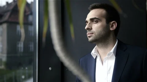Young businessman looking out of a window Видео 42138176