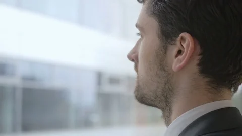 Young businessman looking through the window as he takes a break at the office Stock Footage 75550775