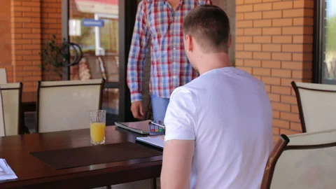 Young businessman makes payment using wireless NSF system in a restaurant Stock Footage 120791202