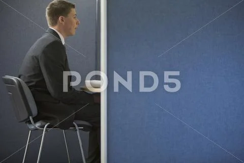 A young businessman in a meeting in an office cubicle Stock Photos