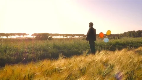 Young businessman in the middle of the nature with baloons Stock Footage