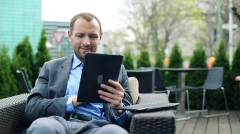 Young businessman with modern tablet computer sitting in cafe HD Video stock 37184613