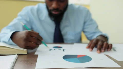 Young businessman or analyst analyzing investment project and sitting at table Stock Footage 172463089